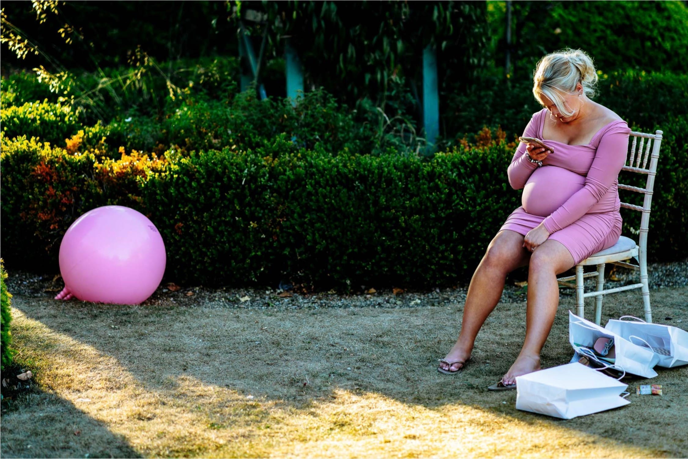 A heavily pregnant woman sits down at a celebration